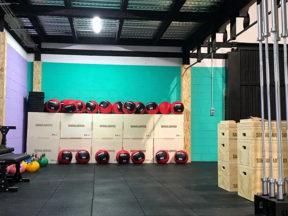Interior del box con paredes turquesa, cajones y balones medicinales