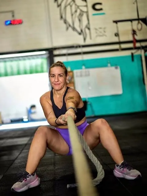 Atleta tirando de una cuerda sentada en el suelo
