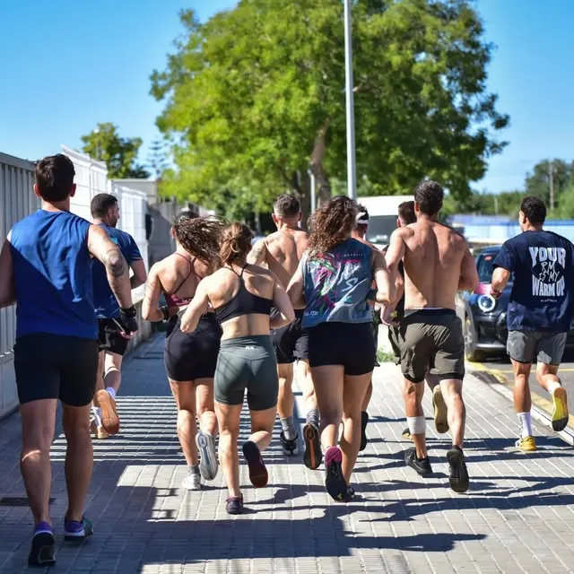 Grupo corriendo por la calle en un día de sol