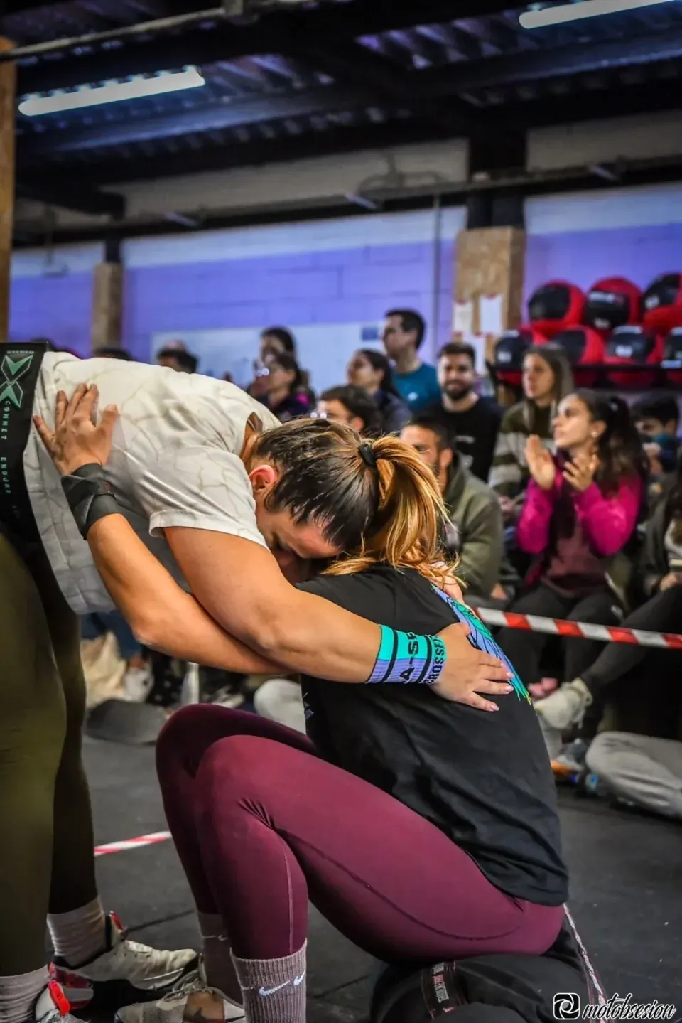 Atleta levantando un saco pesado ante el público